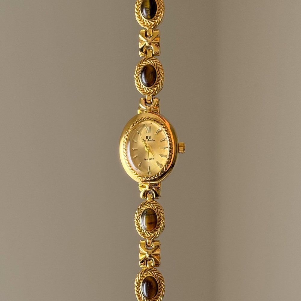 Vintage style gold tone watch with brown gemstone